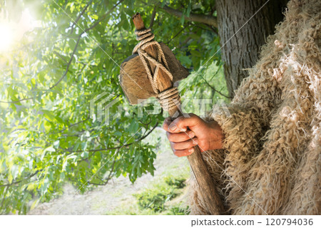 Old hand with stone axe 120794036