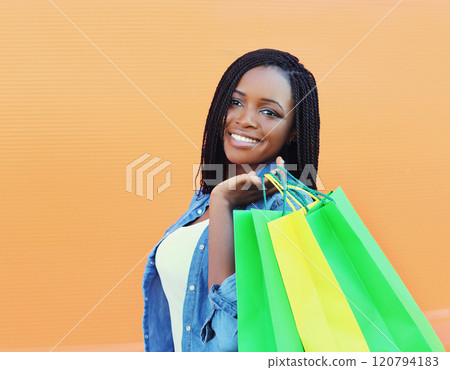 Portrait beautiful smiling young african woman with shopping bags in city Portrait beautiful smiling young african woman with shopping bags in city 120794183