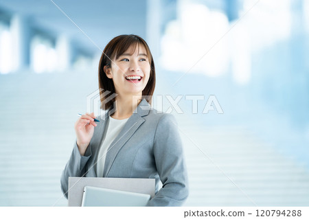 A woman in a suit going to work, an office lady walking through a bright lobby, a working office lady 120794288