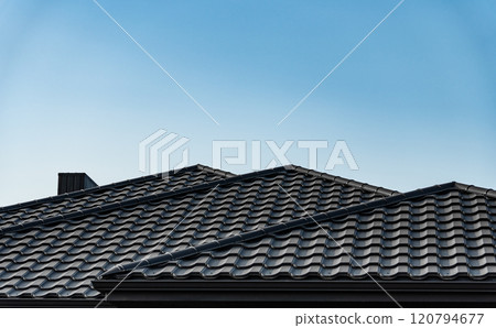 Modern roof covered with black metal tiles. Roof metal sheets. Building 120794677