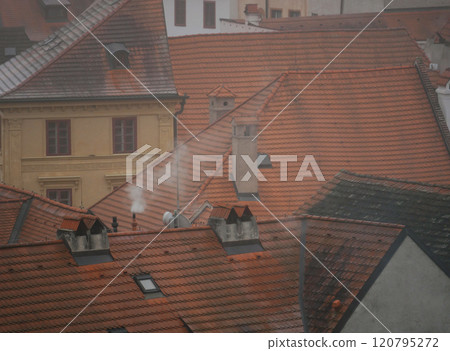 Smoke from the chimney top view. Wood-fired stove heating in winter in Cesky Krumlov, Czech Republic. Air pollution ecological environmental concept 120795272