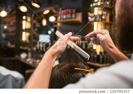 Close-up photo of barber cutting wet hair. Professional hairdresser making fresh hairstyle. Back view of man getting new haircut. Close-up photo of barber cutting wet hair. Professional hairdresser making fresh hairstyle. Back view of man getting new haircut. 120795557