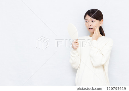 Middle-aged woman checking her skin 120795619
