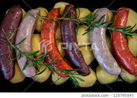 Close-up of bowl with raw homemade blood sausage, pork sausage and chorizo in oven with potatoes. homemade traditional food 120795845