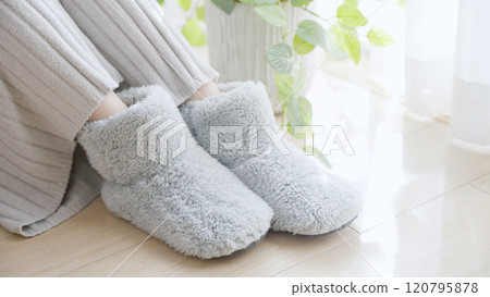 A woman with poor circulation wearing room shoes 120795878