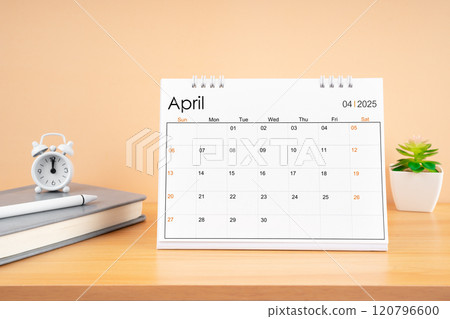 April 2025, Monthly desk calendar for 2025 year on wooden table. 120796600