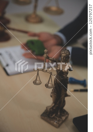 Judge gavel and miniature car symbolize auction or court case against driver who has accident and receiving vehicle insurance payment be on table in front of hands of lawyers. Selective focus Judge gavel and miniature car symbolize auction or court case against driver who has accident and receiving vehicle insurance payment be on table in front of hands of lawyers. Selective focus 120797257