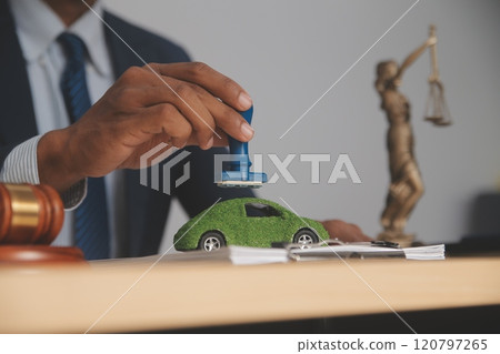 Judge gavel and miniature car symbolize auction or court case against driver who has accident and receiving vehicle insurance payment be on table in front of hands of lawyers. Selective focus 120797265