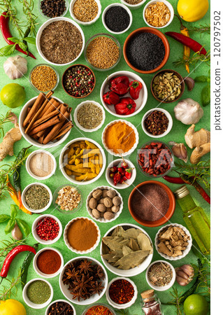 Brightly colored spices and herbs arranged on a delicate green background, highlighting their freshness and fragrance for a lively, natural look 120797502