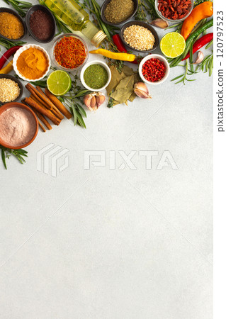 Colorful herbs and spices scattered across a gray surface, ideal for creating authentic and flavorful dishes, top view and copy space 120797523