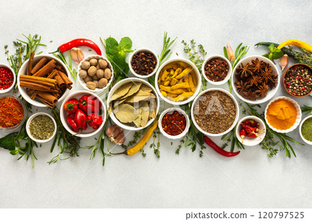 A collection of various spices and herbs on a gray background, perfect for enhancing dishes with rich flavors and textures 120797525