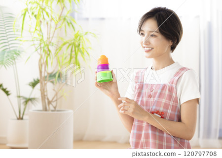 Portrait of a nursery teacher: A woman holding a toy Portrait of a nursery teacher: A woman holding a toy 120797708