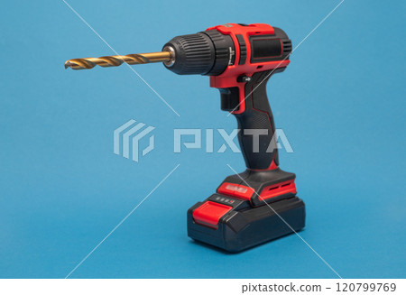 a cordless screwdriver with a drill bit. on the blue 120799769