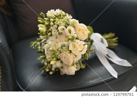 a bouquet of white roses on a beautiful armchair 120799781