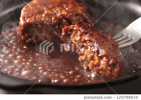 Juicy hamburger steak cooked on a hot iron plate, steaming hot Juicy hamburger steak cooked on a hot iron plate, steaming hot 120799819