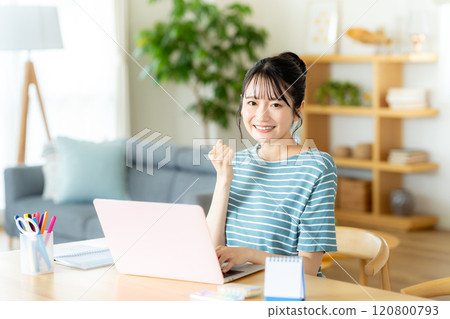 A woman using a laptop in the living room 120800793