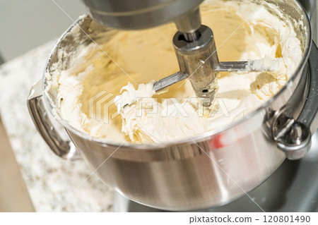 Stand mixer whips up creamy buttercream frosting to perfection, ready for dessert decorating. Stand mixer whips up creamy buttercream frosting to perfection, ready for dessert decorating. 120801490