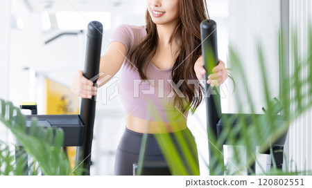 A woman riding a running machine 120802551