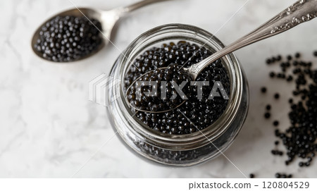 Black Caviar in Glass Jar with Silver Spoon 120804529