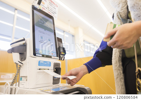 A young woman taking a receipt at a supermarket self-checkout A young woman taking a receipt at a supermarket self-checkout 120806584