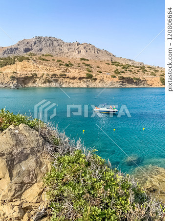 Serene bay with a boat under a clear sky and rocky coastline landscape. High quality photo 120806664