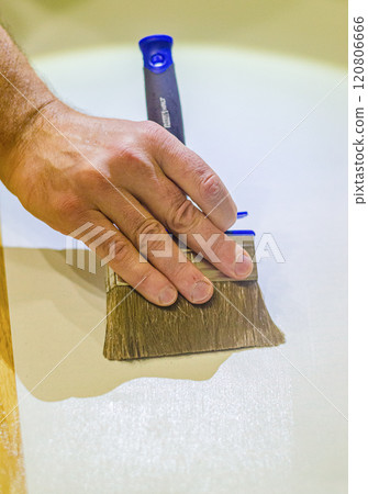 male hand applying colourless glue by brush for gluing wallpaper . High quality photo male hand applying colourless glue by brush for gluing wallpaper . High quality photo 120806666