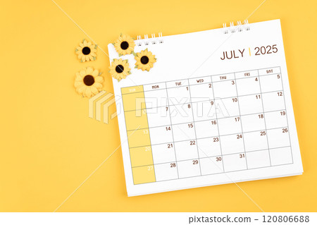 2025 July desk calendar and sunflowers on yellow background. 2025 July desk calendar and sunflowers on yellow background. 120806688