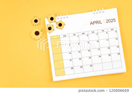 2025 April desk calendar and sunflowers on yellow background. 2025 April desk calendar and sunflowers on yellow background. 120806689