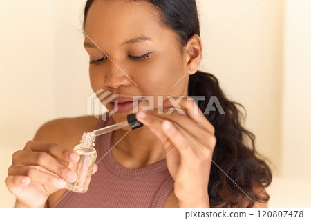 Woman Applying Face Serum for Glowing Skin in Natural Light Setting Woman Applying Face Serum for Glowing Skin in Natural Light Setting 120807478