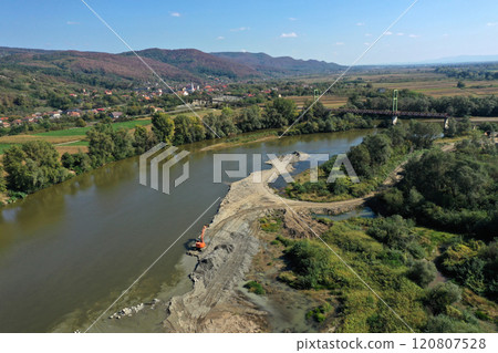 Aerial view of illegal exploitation of river sand and gravel with excavator on river bank 120807528