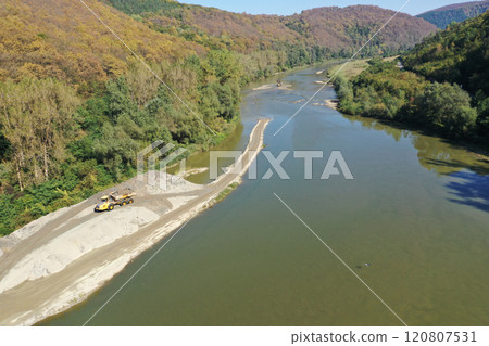 Aerial view of illegal exploitation of river sand and gravel with excavator on river bank Aerial view of illegal exploitation of river sand and gravel with excavator on river bank 120807531