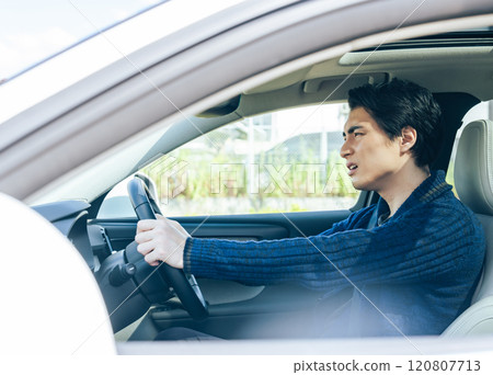 A scene in a car of a male driver driving an automobile with anxiety A scene in a car of a male driver driving an automobile with anxiety 120807713