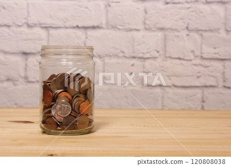 Glass Jar of American Coins on Wooden Table 120808038