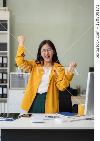 Portrait of a successful business woman with inspiration from their excellent financial results front at the desk, looking to camera. Portrait of a successful business woman with inspiration from their excellent financial results front at the desk, looking to camera. 120808173