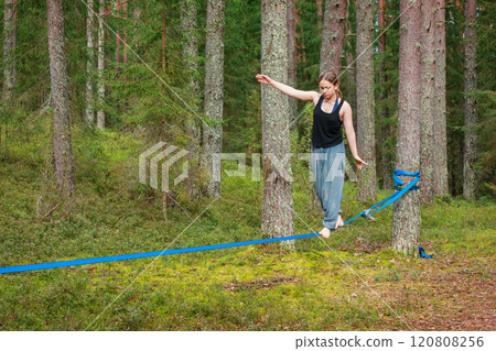 Teenage girl practicing slacklining outdoors 120808256