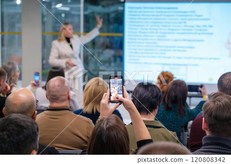 Audience capturing presentation with smartphones during business seminar 120808342