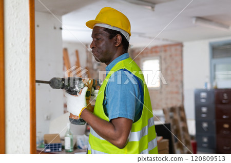 Focused african american builder working with pneumatic jackhammer 120809513