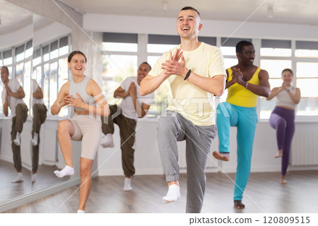 European guy with team of like-minded multinational people learn to elements of hip hop dance 120809515