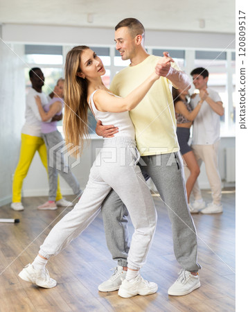 Group of men and women of different nationalities learn to dance the waltz in dance studio Group of men and women of different nationalities learn to dance the waltz in dance studio 120809517