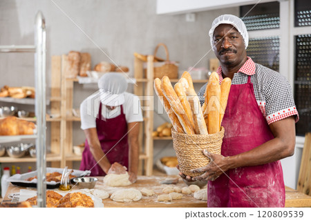 Successful African baker presenting golden baguettes in bakery 120809539