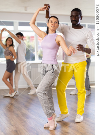 Couple male and girl rehearsing pair latino dance in studio 120809578