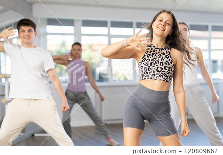Young girl practicing hip-hop dance in training hall in group 120809662