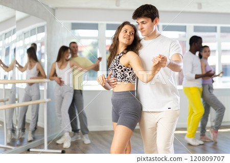 Young couple practicing passionate samba in dance class Young couple practicing passionate samba in dance class 120809707