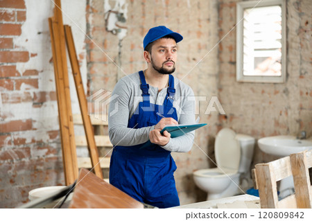 Male foreman checks the completed construction work on drawing Male foreman checks the completed construction work on drawing 120809842