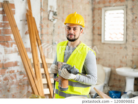 Confident builder posing on indoor construction site Confident builder posing on indoor construction site 120809882