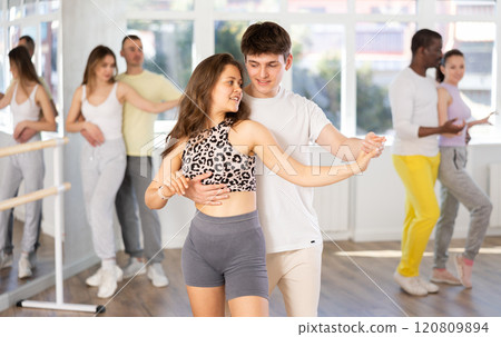 Expressive young couple enjoying impassioned merengue in dance class 120809894