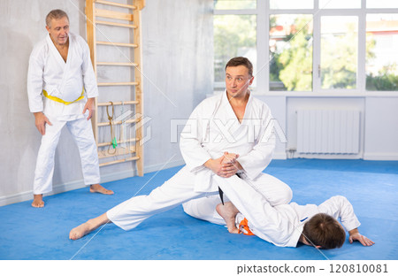 Adult and young men training judo fight 120810081