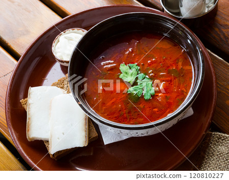 Borsch red soup with pork and sour cream, served with bread and salo Borsch red soup with pork and sour cream, served with bread and salo 120810227