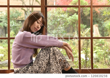 Portrait of a young woman standing on the porch Portrait of a young woman standing on the porch 120810238