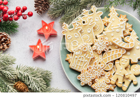 Christmas cookies decorated with icing celebrating christmas eve with candles and pine branches Christmas cookies decorated with icing celebrating christmas eve with candles and pine branches 120810497